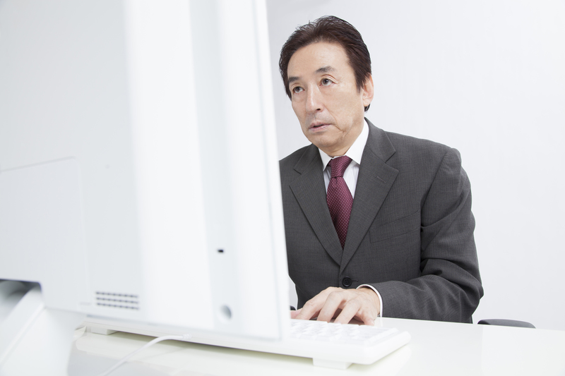 デスクワークをする中年男性