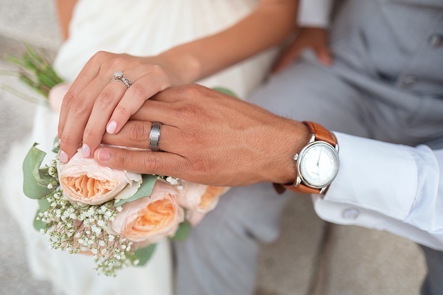 結婚指輪を見せるように重なる男女の手