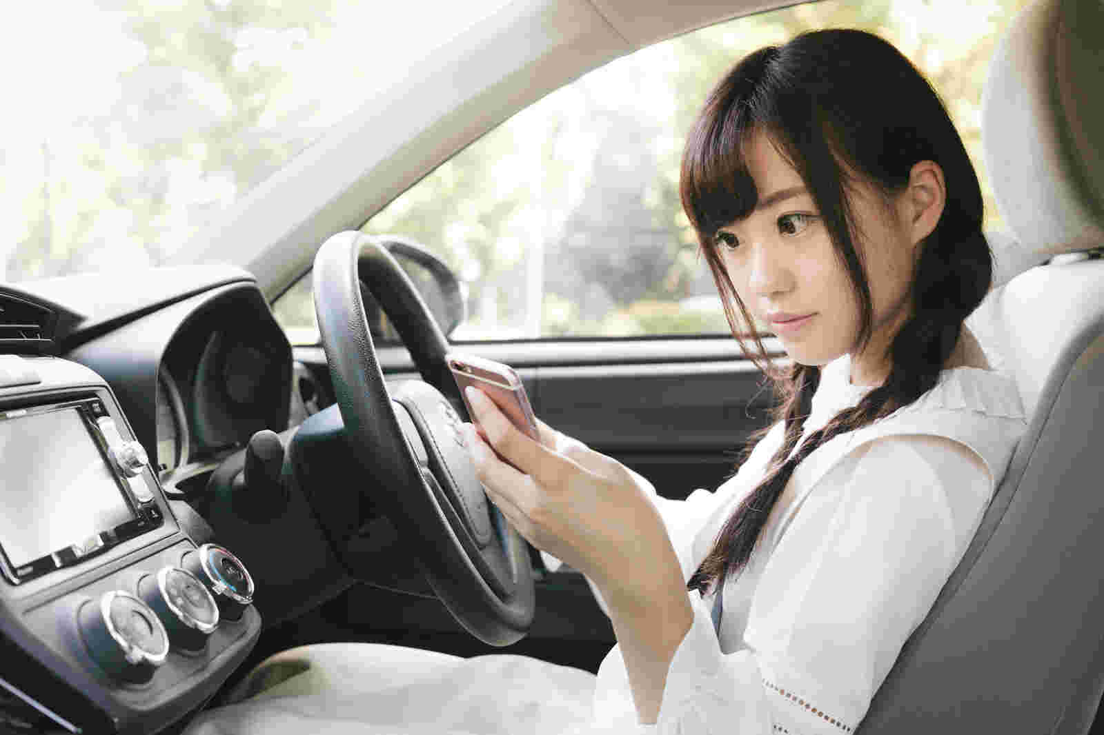 車内でスマホを操作する女性