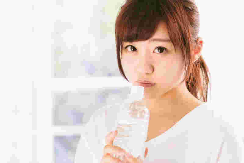 水を飲む上目遣いの女性