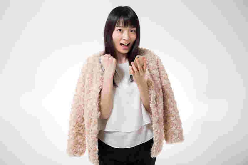 スマホをもってガッツポーズする女性