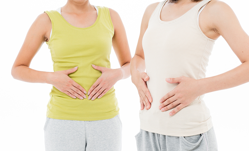 お腹に両手をあてている2人の女性