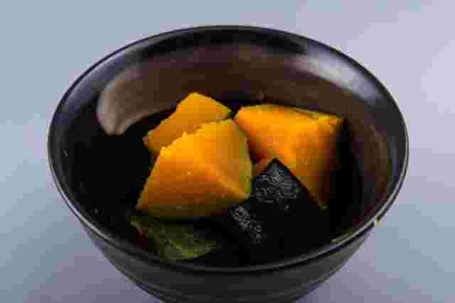 黒い小鉢に入ったかぼちゃの煮物