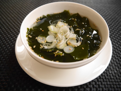 黒いクロスの上に白い器に入ったわかめスープ
