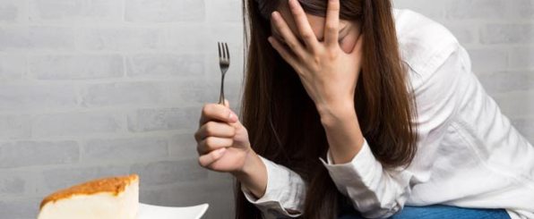 ケーキを前に頭を抱える女性