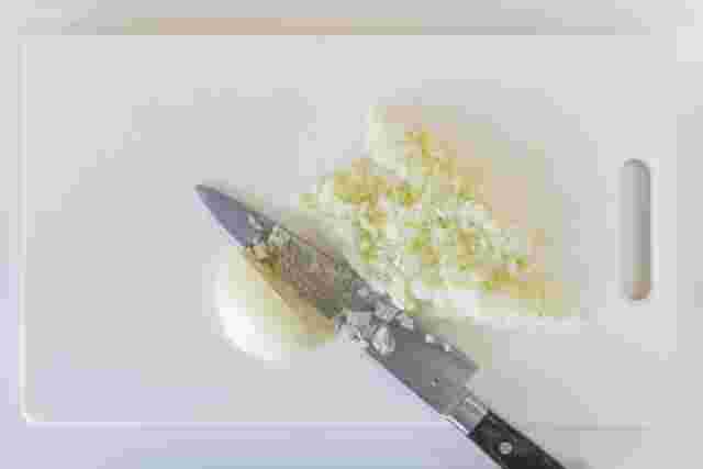 プラスチックのまな板の上で玉葱をみじんぎりにした様子