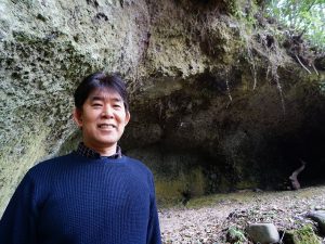 ▲竹田のキリシタン研究の第一人者でもある後藤篤美さん。平成24年の『岡藩城下町400年祭』を記念して、市の広報に『竹田キリシタンの歴史』を執筆することになったのがきっかけで研究をはじめた。「調べれば調べるほど、竹田のキリシタン伝説は無尽蔵に出てきますからとても面白い」と後藤さん。後藤さんの執筆記事は『ミステリアス!竹田キリシタン』と名づけられ、竹田市のホームページに掲載。その記事が全国から注目を集めるようになり、竹田の観光資源として生かされるようになった。(奥に写っているのは宣教師の住まい兼集会所として使われていたと思われる手彫りの洞窟)