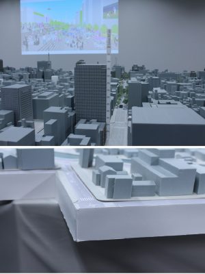 かつて模型は、住宅地図と航空写真をなぞって作られ、ビルやマンションの階数については実際に現地に出向いて確認をしていた。それが、技術の進歩により航空測量で細かいところまで分かるようになり、「画期的」と山本さんは語る。「Sakae-BA400」では、比較的目印などになるビルに紙で窓の形を再現して貼り付けてある。写真上は、実際の高さが分かる定規を中央のビル横に置いてみたところ。写真下は、土地の高低差を調整する台座