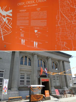 佐賀市では 2019年1月14日まで「肥前さが幕末維新博覧会」を開催中。船着場の横にある、昭和9年に建設された旧銀行をパビリオン「オランダハウス」(写真下)にして、水辺の暮らしを提案。佐賀とアムステルダムを比べるパネル(写真上)は川﨑さんがデザインに参加した