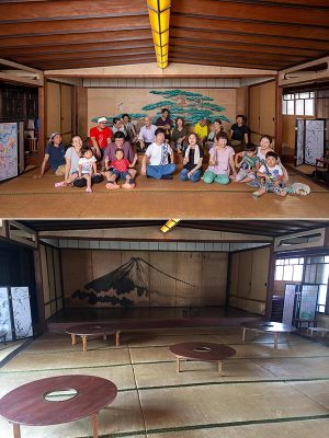 「寿ゞ家」本館2階、30畳の大広間。舞台上の背景は、扉の表に富士山が描かれ、扉を開けたその奥に松と鷹が描かれている。上の写真中央の白いシャツを着ているのが天野さん(写真提供:天野さん)。<br>「最初はこの広間にも埃が数センチ積もっていて、土足で歩いていました。掃除をして畳を水拭きして人がまた出入りするようになると不思議なもので畳も建物自体もシャンとしてくるんです」。今回のプロジェクトで改めて木造建築の再生力の強さを感じたという