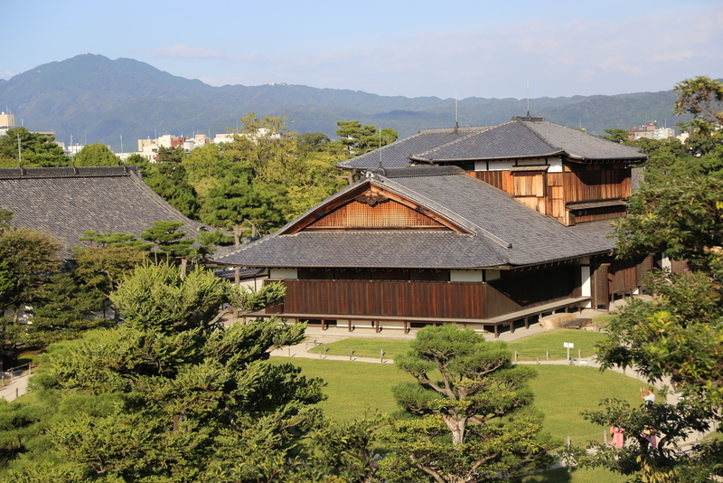【二条城天守台から本丸御殿を撮影】<p>正面の建物が二条城の本丸御殿。</p>
<p>江戸時代の本丸御殿は、1788年の市中の大火で消失した。<br>現在の本丸御殿は、1893年から翌年に京都御苑今出川御門内の旧桂宮御殿を移築したもの。14代将軍、徳川家茂に嫁いだ皇女和宮が約１年８ヶ月間、居住した。また、孝明天皇の仮皇居として使用されたこともある。</p>
<p>なお、天守台でこの見晴らしなので、五層の天守閣上からはかなりの高さだったはず。</p>
