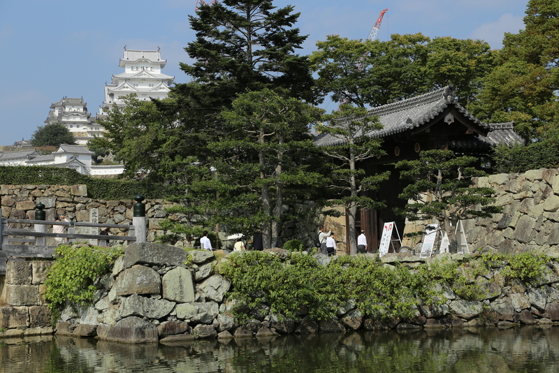 【姫路城大手門】<p>姫路城大手門の高麗門（右）と背後の天守。<br>左手の橋が桜門橋で、2007年に江戸期の木橋をイメージして復元されたとのこと。</p>
<p>江戸城や大坂城の大手門は切込み接ぎの石垣だが、姫路城の大手門は意外と巨石は少なく規格化されていなかった。</p>