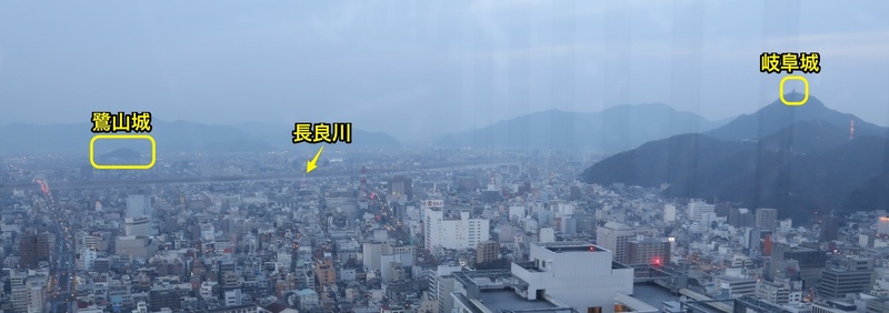 【岐阜駅前から鷺山城ー岐阜城を撮影】岐阜駅前の岐阜シティタワーの43階から鷺山城と岐阜城を撮影。

鷺山城は、斎藤道三が息子の斎藤義龍に家督を譲り、隠居した時に入った城と伝わる。
道三が隠居したので、斎藤義龍が岐阜城（稲葉山城）に入った。

のちに、道三と義龍は長良川を挟んで対立した。そして、1556年合戦に及んで、道三は敗れ、義龍勢に討たれた（長良川の戦い）。

長良川を挟んでいたとはいえ、鷺山城と岐阜城は直線距離にして3kmちょっと。
一旦対立関係になると、かなりの緊張感だったのではないか。

＊なお、本当は岐阜城に行きたかったのですが、時間がなくて断念。岐阜駅前の観光協会のおねえさんに岐阜シティタワーの展望台（43階）を教えてもらいました。その結果、イメージ通りの一枚を撮れて、大満足。これぞ不幸中の幸い。
