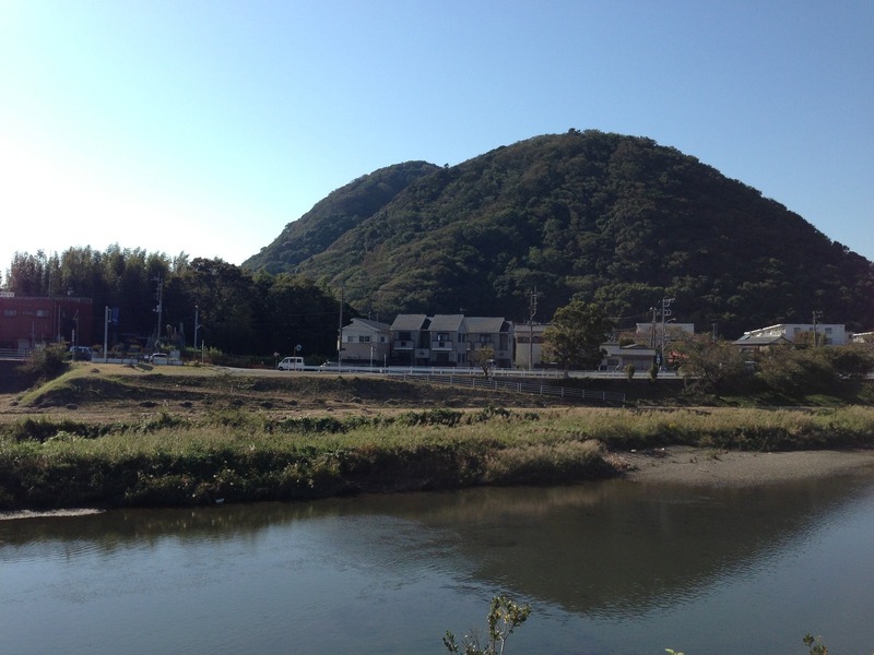 【高麗山城】高麗山城遠景。平塚方面から。手前は花水川。乃至政彦『上杉謙信の夢と野望』の小田原攻撃（1561年）の辺りを読んでいたら、景虎が高麗山城の麓に本陣を置いたとあった。高麗山城は北条早雲の文脈でしか意識していなかったので、軽い驚きがあった。