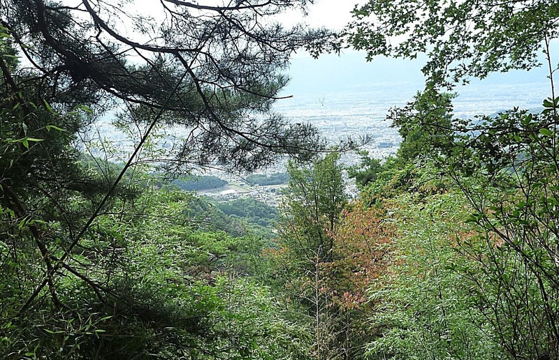 【要害山城】不動曲輪から甲府盆地を撮影。中央やや左手に湖が見えるが、その右手の緑が躑躅ヶ崎館。撮影した時は躑躅ヶ崎館の位置が分からなかったが、写っていてラッキーだった。撮ってみるものだと思いまする。