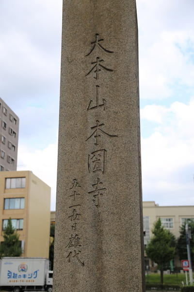 本圀寺跡の石碑。<br><br>1568年、織田信長の後ろ盾を得て、上洛を果たした足利義昭は本圀寺（日蓮宗）に入った。しかし、翌年、京都を追われた三好三人衆は反撃に転じて、本圀寺を襲撃した（本圀寺の変）。<br><br>現在、本圀寺は京都の山梨にある。