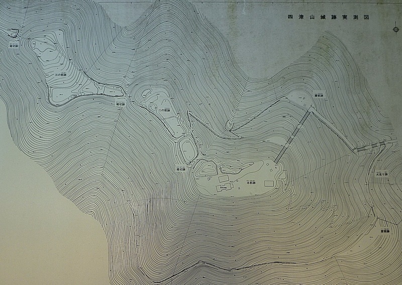 【高見城】現地案内板の縄張り図。高見城へは右（東の山麓）から入る。<br>      登り始めて、すぐに犬走りがある。そのまま進むと、腰郭跡へ。階段を登って、本郭跡→二の郭→三の郭となる。