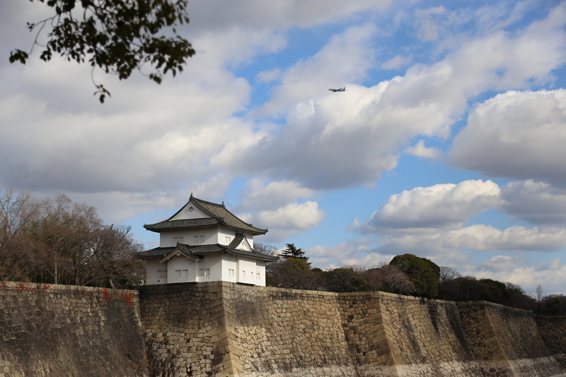 【大阪城】南外堀の六番櫓と右上上空を通る飛行機。<br>      大坂城見学中に、何度も上空を飛行機が音を立てて飛んでいった。<br>      江戸城見学時にはない光景。