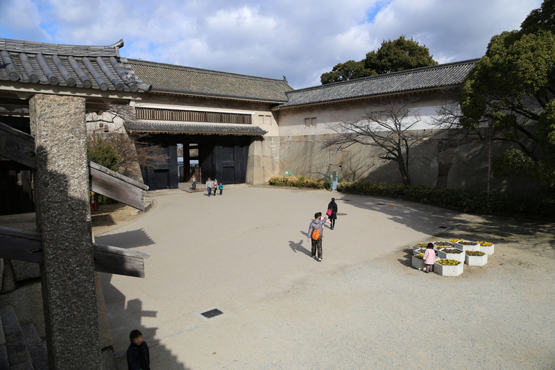【大阪城】大手口枡形櫓門（左側の櫓）と続櫓。<br>      日本最大級の枡形というだけあって、広い。<br><br>      高麗門の雁木上から撮影している。左側に高麗門の土塀を支える石控柱（いしひかえばしら）が部分的に写っている。