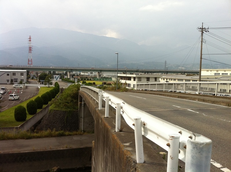 滝沢川の橋の上から富田城があったといわれる甲西工業団地をのぞむ。 中部横断自動車道が団地内を通っている。背後が南アルプス。