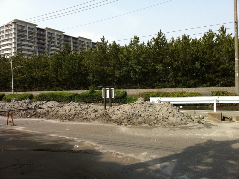 【液状化が起きた道路ー東日本大震災発生から約50日後の浦安ー】液状化で噴出した砂が掻き上げられ、延々と続いていた。