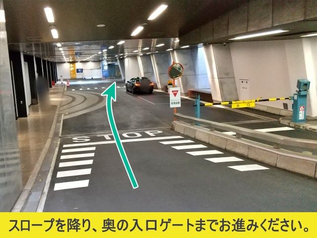 スロープを降り、奥の入口ゲートまで進んでください。