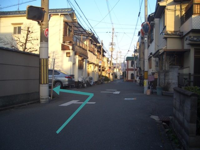 こちらの道路を矢印の方向に曲がってください。