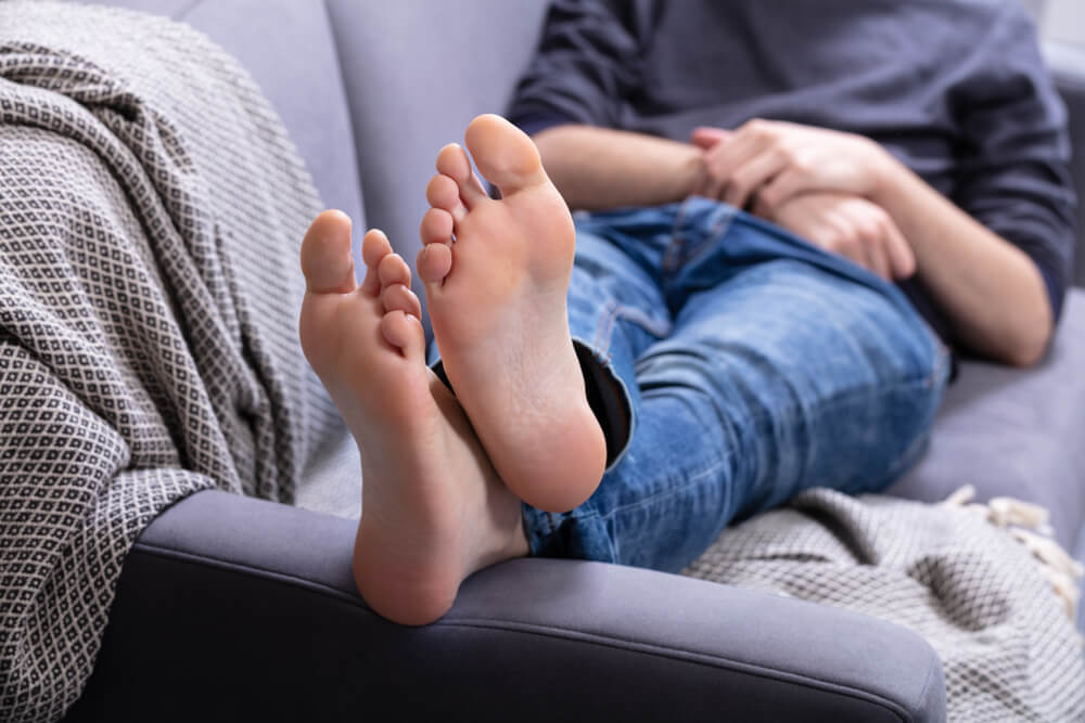 ソファに寝転がる男性