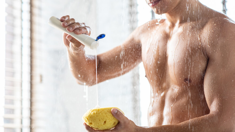 スポンジにボディソープを付ける男性