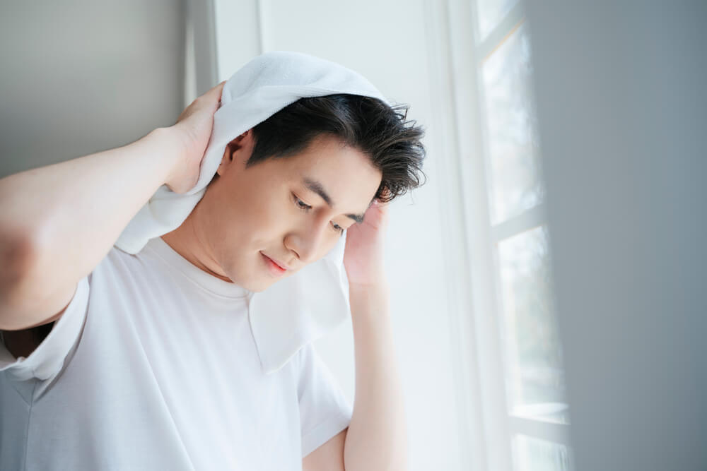 髪をタオルで拭く男性