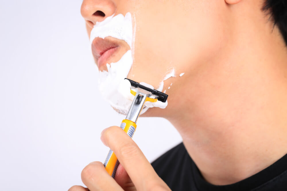 シェービングフォームを使ってヒゲを剃る男性