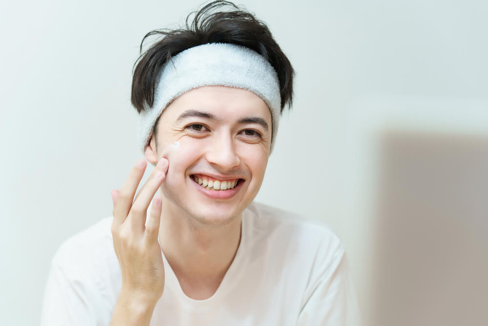 顔にクリームを塗る男性