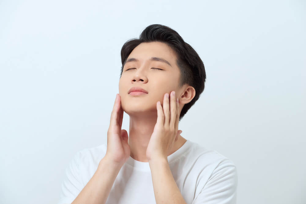 頬に手を当てる男性