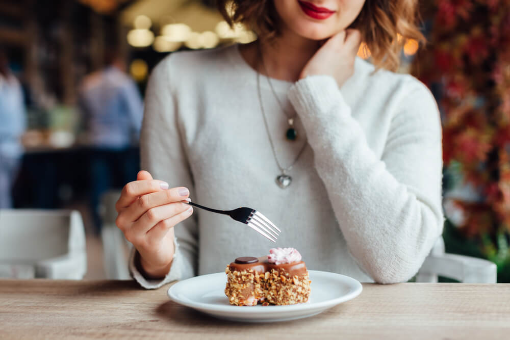 カフェでケーキを食べようとする女性