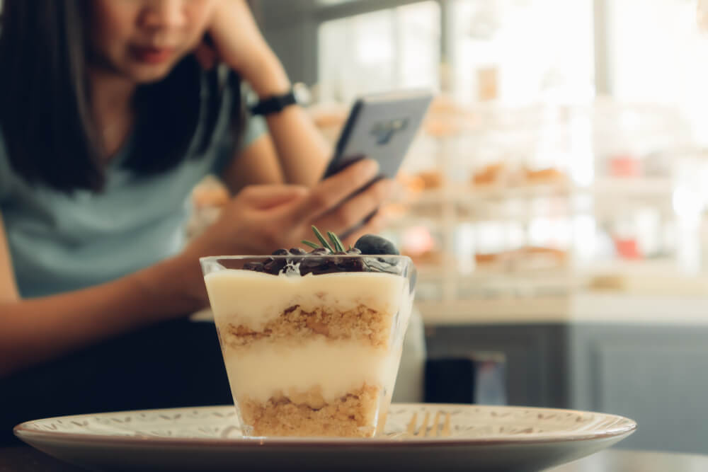 カフェでスマートフォンを見る女性
