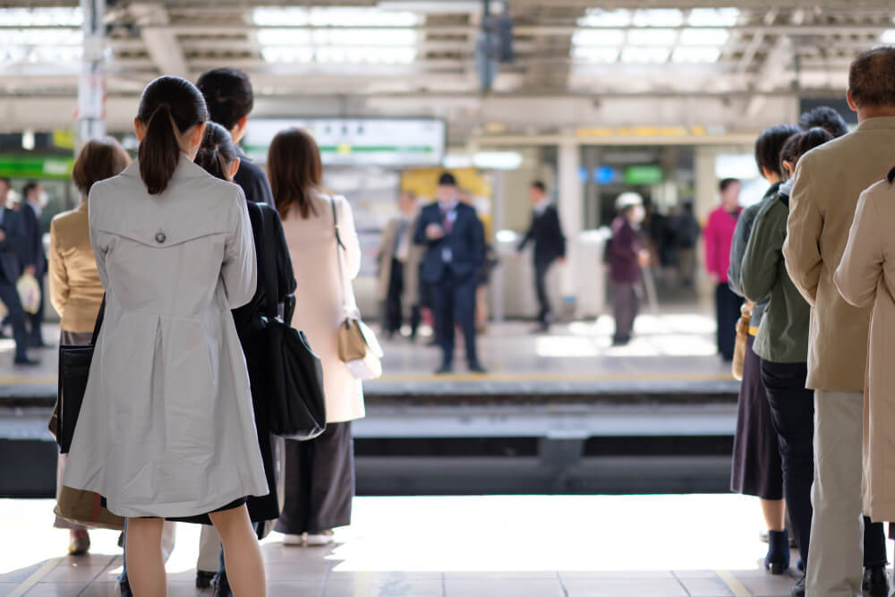 駅のホームで待つ人々