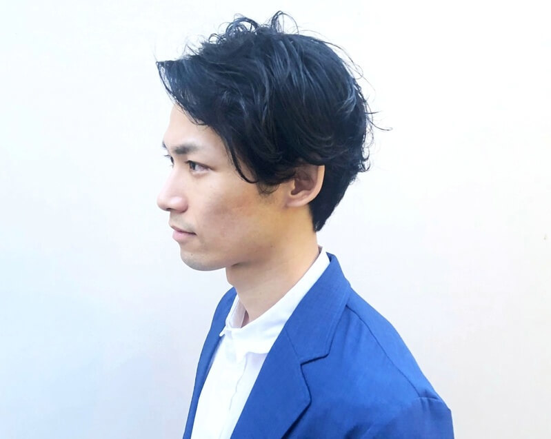 ゆるいパーマスタイルの男性