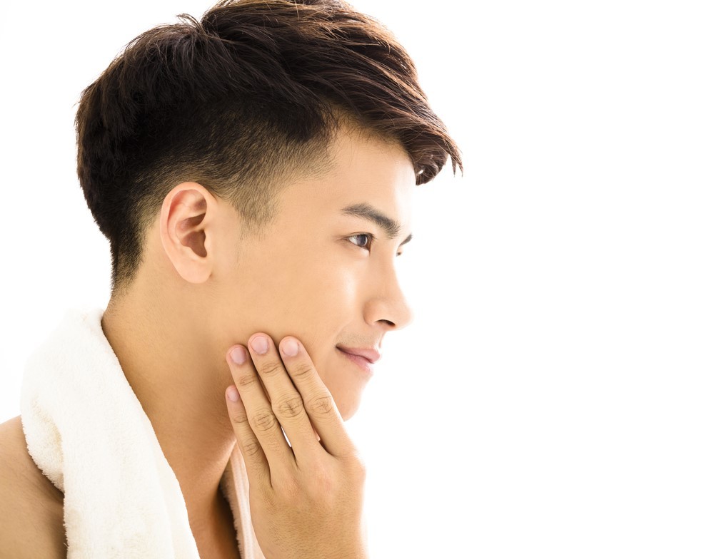 洗顔後の肌をチェックする男性
