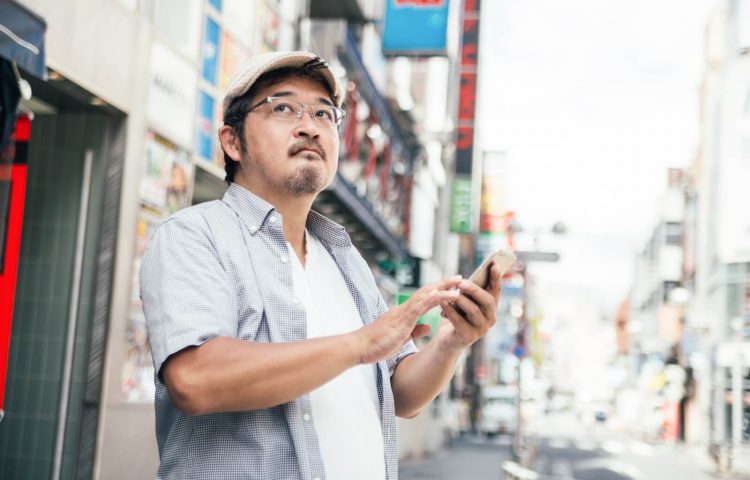 エックスモバイルの料金プランで料金を計算する男性