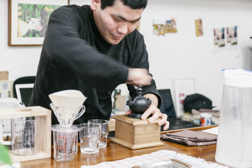 コーヒーを挽く、スタジオクーカの作家・水野 貴男さん。