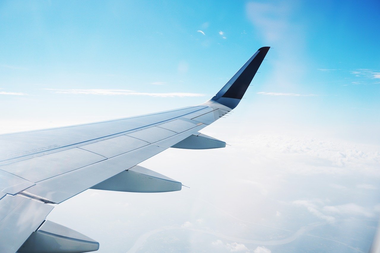 飛行常客計劃:飛機在高空中白色的雲與藍色的天