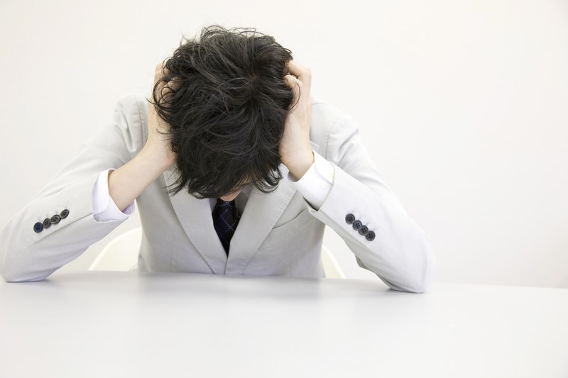 ストレスで頭を抱えている人