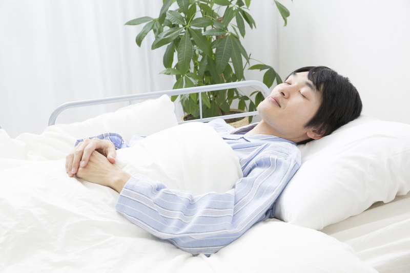 病室で横になる患者さん