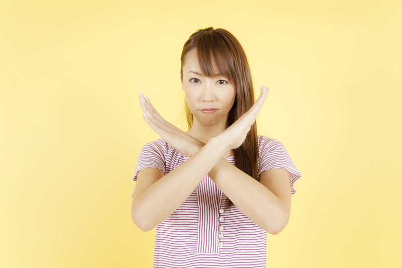 両腕でバツ（✕）マークを作っている人