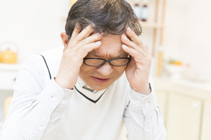 頭を押さえる男性