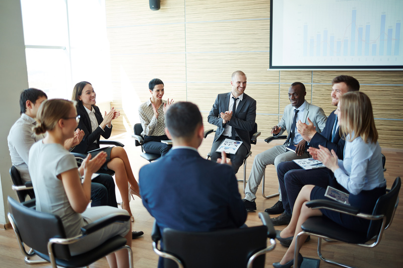 輪になって色々な年齢のビジネスマン（男女とも）が話している懇親会風の素材写真
