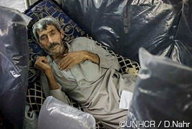ムハンマド・アリは55歳の肺病を患う難民であり、トルコとイラクのクルディスタン地域の間の国境で、ガウィラン難民キャンプへと向かうバスの中に横たわっています。