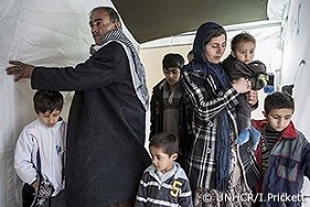 トルコ南部のSuracキャンプにあるテントの外に立つ、エイシャ、ワザムとその6人の子どもたち。新たに開かれた難民キャンプについて耳にした彼らはそこへ行き、数時間のうちに登録され、テントを割り当てられた。エイシャはいつかシリアに戻ることを望んでいるが、現在この家族は他に行き場はない。