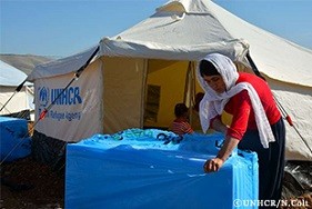 7児の母であるライラは、家族がこの冬の寒さをしのぐための防寒材などが入った箱を開けています。