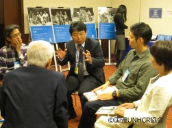 熱心に参加者と話す佐藤滋之UNHCR職員(中央)